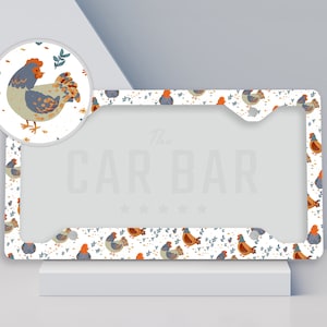 May include: White license plate frame with a repeating pattern of blue and orange chickens. The text "The Car Bar" is printed in the center of the frame.
