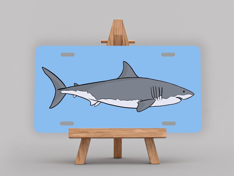 May include: A blue and white great white shark illustration on a light blue background. The image is displayed on a wooden easel.