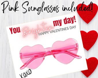 May include: A Valentine's Day card with the text "You brighten my day! Happy Valentine's Day" and "xoxo". The card features a pair of pink heart-shaped sunglasses.