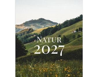 Op de afbeelding: Een wandkalender met een spiraalbinding aan de bovenkant, voorzien van een landschapsfoto van groene heuvels, verre bergen en een weide met gele wilde bloemen. De tekst NATUR 2027 staat in het wit in het midden, met DANIEL SANABRIA VALDÉS eronder.