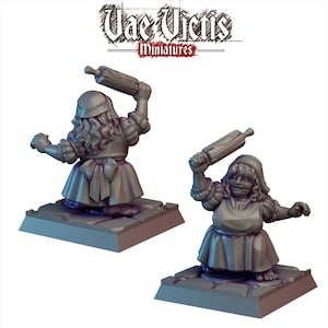 May include: A miniature figurine of a woman wearing a dress and apron, holding a rolling pin above her head. The figurine is painted in a gray color and is standing on a square base.