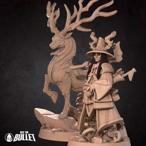 May include: A miniature figurine of a woman wearing a hat and robe, standing next to a deer with large antlers. The figurine is made of a light brown material and is painted in a realistic style.