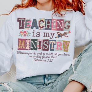 May include: White long-sleeve sweatshirt with the text "TEACHING is my MINISTRY" in colorful block letters. The design includes floral and pencil graphics, and a Bible verse from Colossians 3:23.