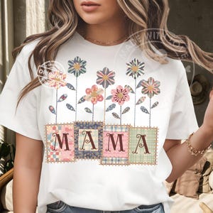 Puede incluir: Camiseta blanca con un diseño floral y la palabra "MAMA" en patchwork. Las flores tienen pétalos estampados y están conectadas a los cuadrados de patchwork por tallos verdes. El diseño tiene una estética vintage.