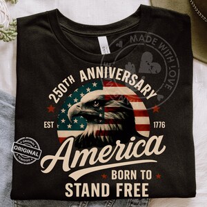 May include: Black t-shirt featuring a patriotic design for the 250th anniversary of America. The graphic includes an eagle, the American flag, and the text "America Born to Stand Free."