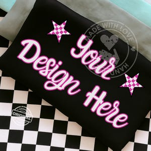 Puede incluir: Tela negra con el texto "Design Your Here" en blanco con un contorno rosa. Dos estrellas rosas y blancas a cuadros están en la tela. El fondo es un patrón de cuadros blanco y negro.