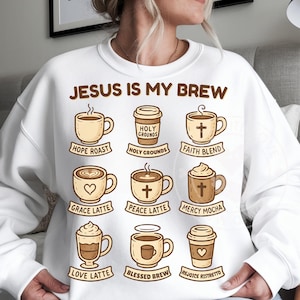 May include: White sweatshirt featuring the phrase "JESUS IS MY BREW" and coffee-themed illustrations. The design includes various coffee cups and takeaway cups, each labelled with names such as "Hope Roast," "Grace Latte," and "Mercy Mocha."