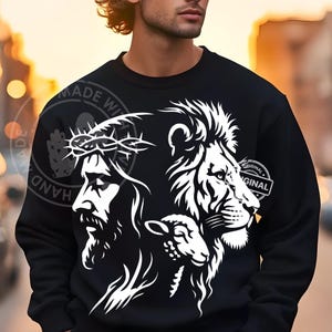 May include: Black sweatshirt featuring a white graphic of Jesus wearing a crown of thorns, a lion, and a lamb. The design includes the words "ORIGINAL" and "HAND MADE WITH LOVE".