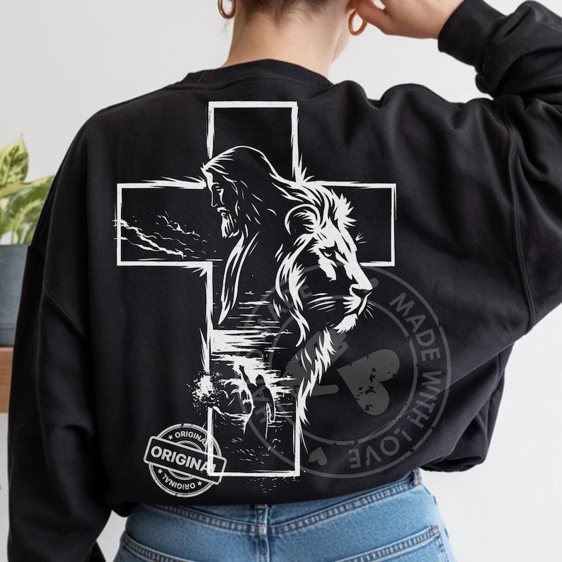 May include: Black sweatshirt featuring a white graphic of Jesus Christ and a lion within a cross. The design includes the text "ORIGINAL" in a circular stamp and "MADE WITH LOVE" in a heart-shaped stamp.