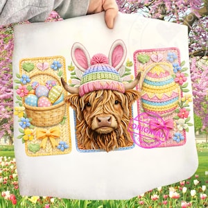 May include: A white print featuring a Highland cow wearing a colorful knit hat with bunny ears. The design includes a basket of Easter eggs and a decorative Easter egg, all surrounded by flowers and bows. The image has a spring theme.