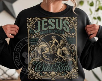 May include: Black sweatshirt with a graphic design featuring a cowboy on a horse, desert scenery, and the words "JESUS GUIDE ME ON THIS WILD RIDE." The design is in shades of green, beige, and brown.