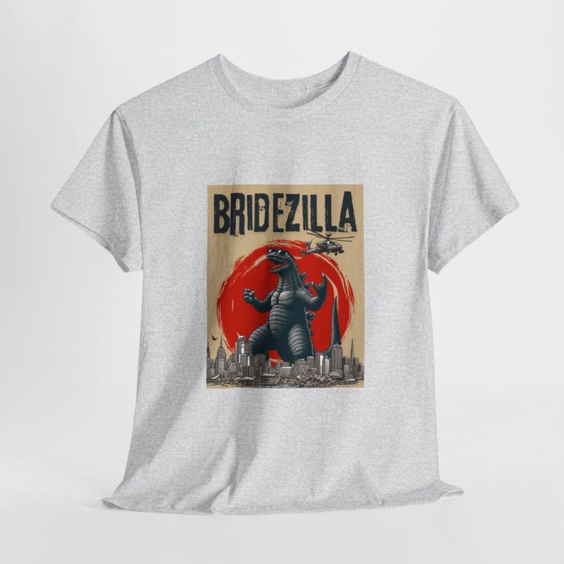 May include: A gray t-shirt with a graphic print of a Godzilla-like monster in front of a cityscape. The text "Bridezilla" is printed above the monster.