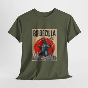 May include: A green t-shirt with a graphic print of a Godzilla-like monster in front of a cityscape. The text "Bridezilla" is printed above the monster.