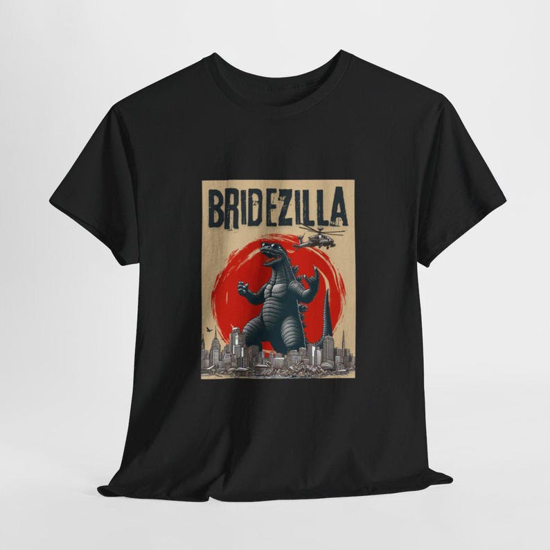 May include: Black t-shirt with a graphic print of a Godzilla-like monster in front of a city skyline. The text "Bridezilla" is printed above the monster.