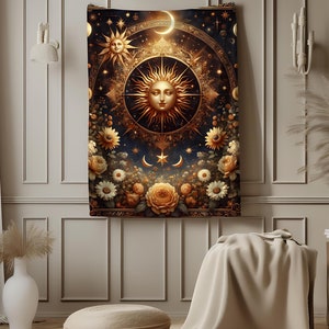 May include: A tapestry featuring a golden sun with a face surrounded by stars and a crescent moon. The sun is surrounded by a floral border with sunflowers and other flowers in shades of yellow, white, and brown. The background is a dark blue with gold accents.