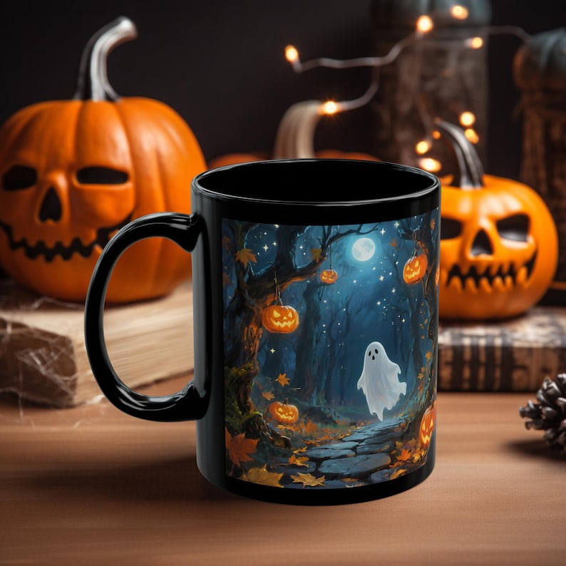 May include: Black ceramic mug featuring a Halloween-themed illustration. The design depicts a spooky forest scene with a ghost, jack-o'-lanterns, and a full moon. The background includes carved pumpkins and string lights, evoking a festive atmosphere.