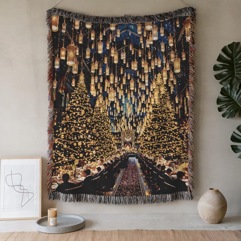 May include: Woven tapestry throw blanket depicting a grand hall with Christmas trees, hanging lanterns, and a long table. The scene is illuminated with warm, golden light, creating a festive atmosphere. The blanket has a fringed edge, and the scene is reminiscent of a magical setting.