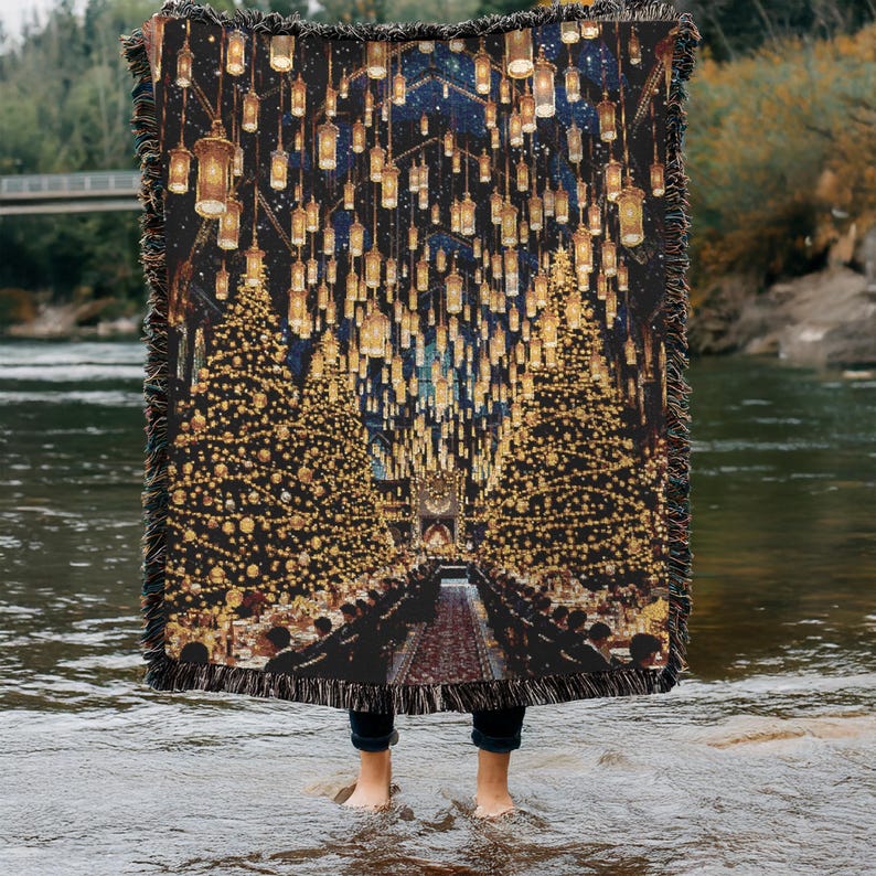 May include: A woven throw blanket depicting a festive hall with Christmas trees and hanging lanterns. The blanket has a dark background with gold and yellow accents, and a fringed edge.
