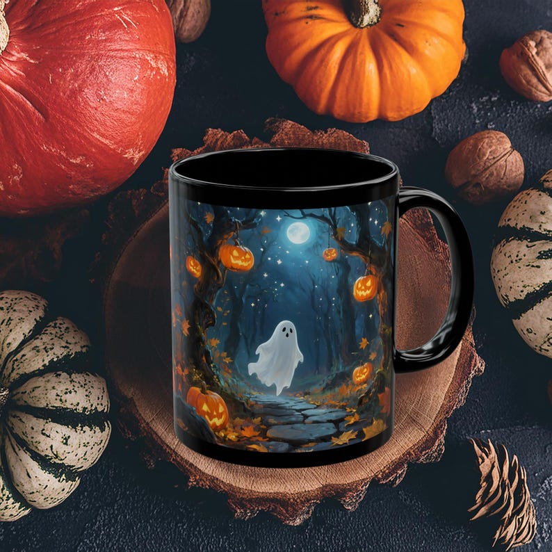 May include: Black ceramic mug featuring a Halloween-themed illustration. The design depicts a spooky forest scene with a ghost, jack-o'-lanterns, and a full moon. The mug is surrounded by pumpkins and gourds, perfect for the fall season.