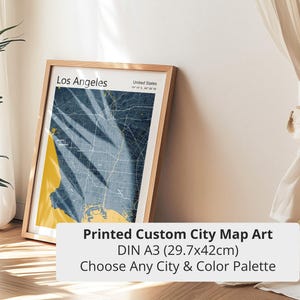 Pode incluir: Uma impressão emoldurada de um mapa de Los Angeles em uma moldura de madeira. O mapa apresenta uma paleta de cores azul e amarelo. O texto na impressão diz "Los Angeles" e "United States". A impressão é DIN A3 (29,7x42cm).