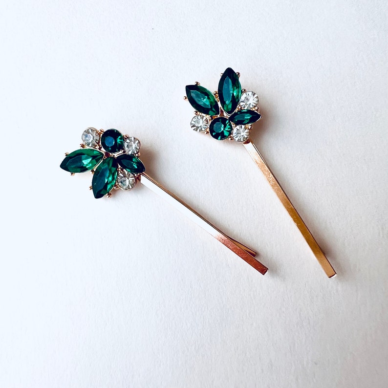 a set of 2 emerald green with rhinestone jewel accents and gold base bobby pin set. Special occasion, gift idea, hair jewelry.
