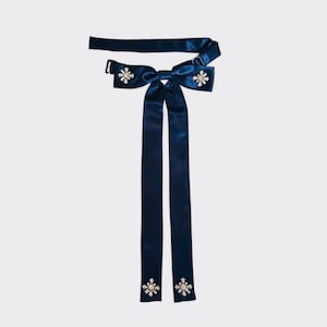 May include: A navy blue bow tie with long tails and crystal embellishments at the center and ends of the tails.