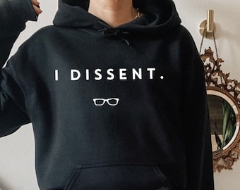 May include: Black hooded sweatshirt with the text "I DISSENT." in white lettering and a pair of glasses icon.