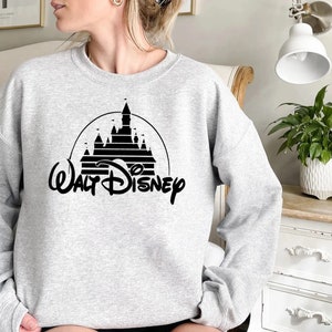 May include: A gray sweatshirt with a black graphic of the Walt Disney castle and the text "Walt Disney" underneath.