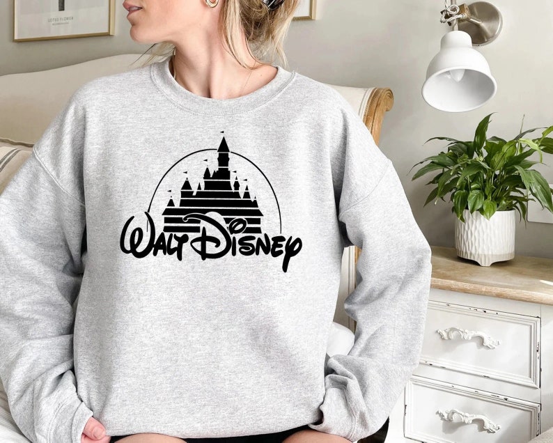 May include: A gray sweatshirt with a black graphic of the Walt Disney castle and the text "Walt Disney" underneath.