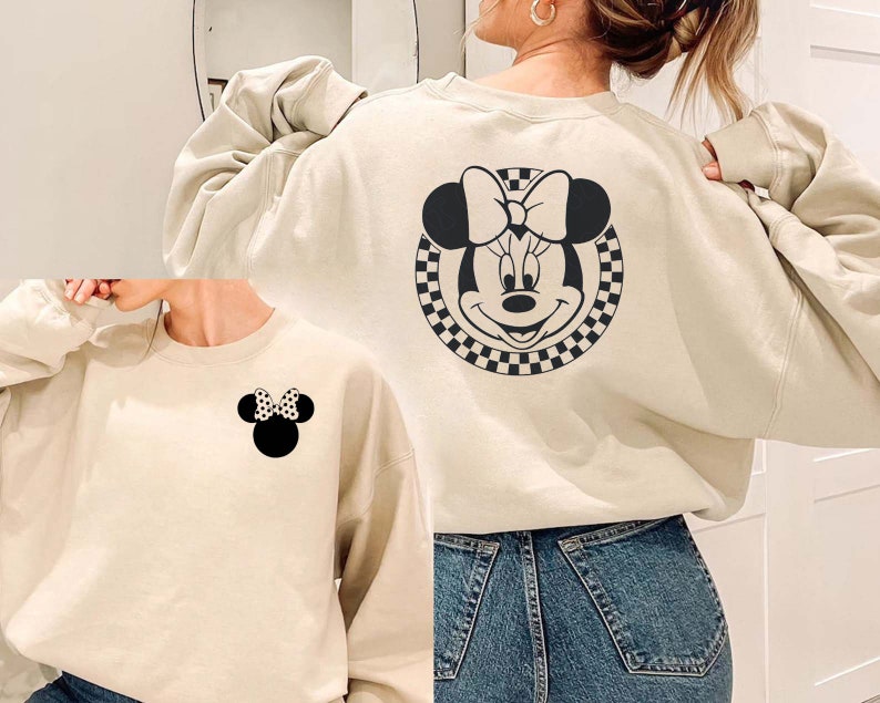 May include: Two cream-colored sweatshirts with a black and white checkered Mickey Mouse design. One sweatshirt has a larger Mickey Mouse design on the back and the other has a smaller Mickey Mouse design on the front.