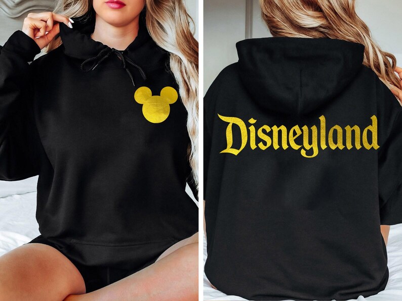 May include: Black hoodie with a gold Mickey Mouse head on the front and the word "Disneyland" in gold on the back.