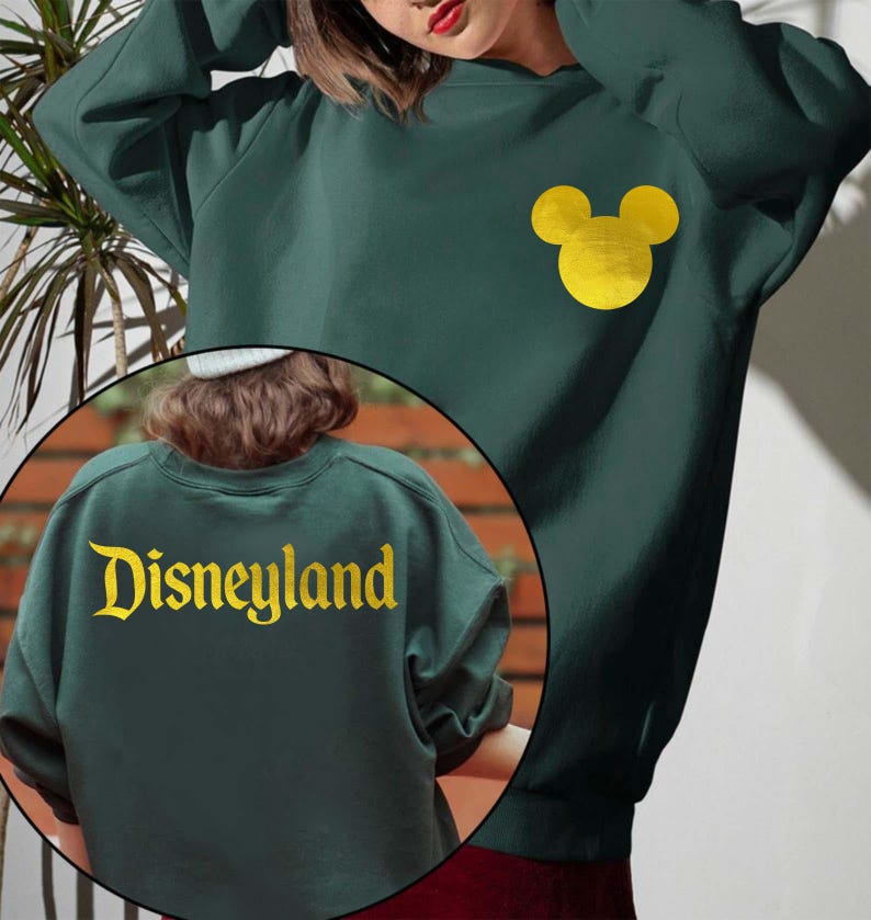 Forest Green Disneyland Sweatshirt With Gold Letter featuring a Minnie Mouse design on the front and Disneyland text on the back, perfect for Disney fans. This cozy Disney Crewneck is great for trips or casual wear.