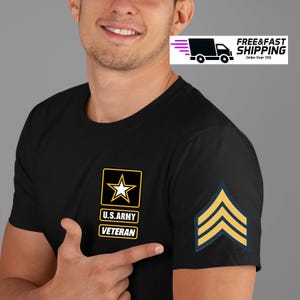 May include: Black t-shirt featuring U.S. Army Veteran insignia with a star and text. The shirt also displays a sergeant's stripes on the sleeve. The person is pointing at the shirt.