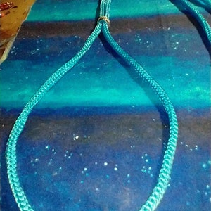 May include: A turquoise blue rope dog leash with a gold metal ring.