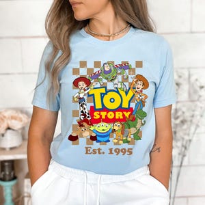 a woman wearing a blue toy story t - shirt