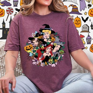 A woman wearing a purple t-shirt with a graphic design featuring cartoon characters and Halloween-themed elements.