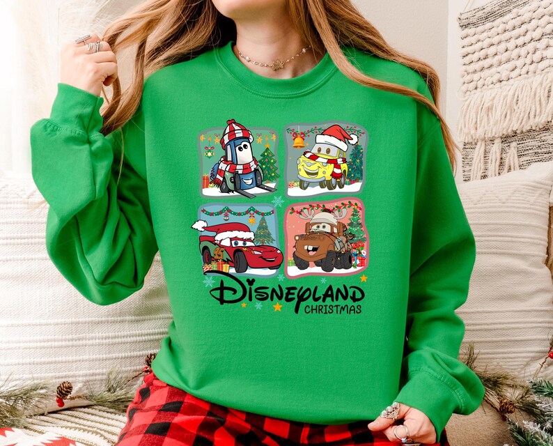A woman wearing a green sweater with a Disney Cars Christmas-themed design.