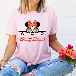 a woman wearing a pink shirt with a minnie mouse on it
