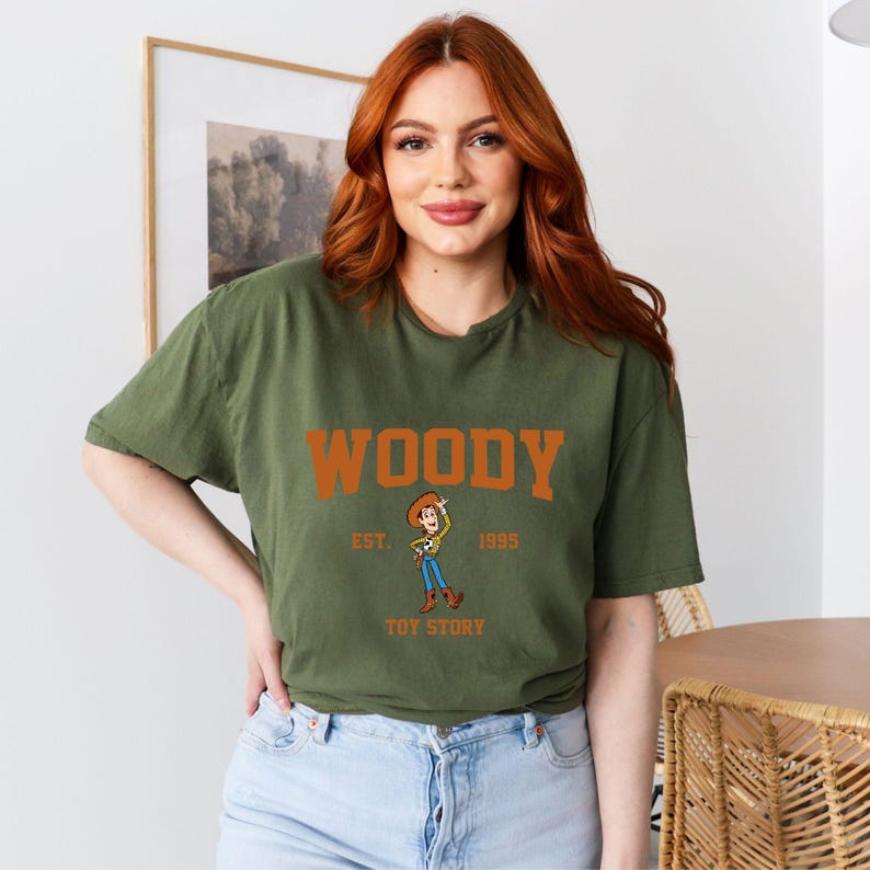 a woman with red hair wearing a woody t - shirt