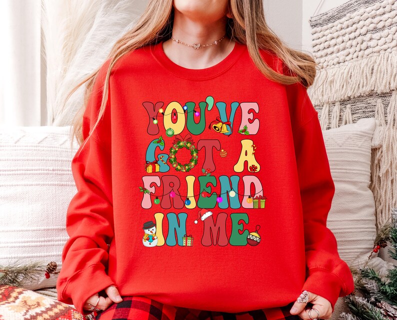 A person wearing a red sweater with the text "YOU'VE GOT A FRIEND IN ME" printed on it.