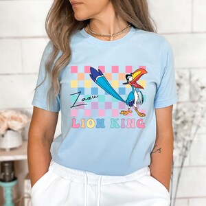 a woman wearing a blue shirt with a bird on it