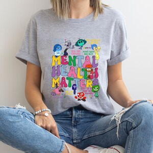 a woman sitting on the floor wearing a t - shirt that says mental health matters