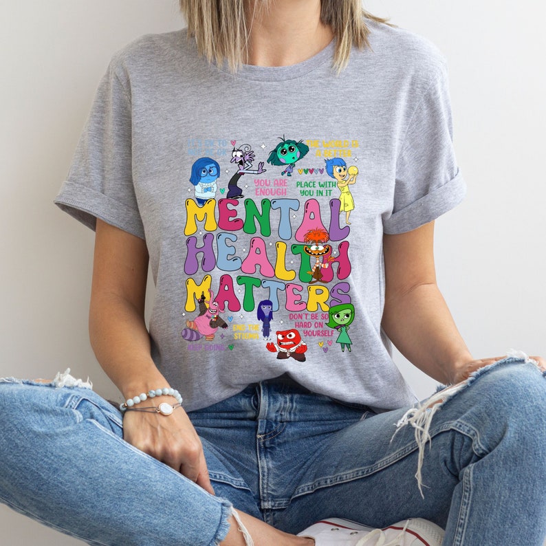 a woman sitting on the floor wearing a t - shirt that says mental health matters