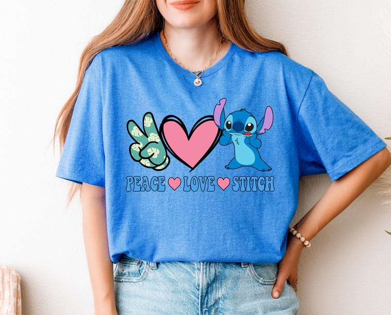 A woman wearing a blue t-shirt with a graphic design featuring a character from the animated series Lilo and Stitch, along with the text "Peace Love Stitch".