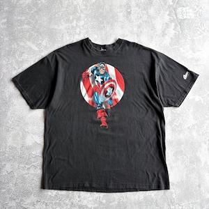 May include: Black t-shirt featuring a Captain America graphic. The graphic shows Captain America in a red, white, and blue circle, holding his shield. The shirt has short sleeves and a crew neck.