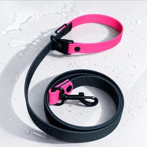 Pode incluir: Um conjunto de coleira e trela impermeável para cão, com uma coleira rosa néon vibrante com ferragens pretas e uma trela preta a condizer. A trela inclui um mosquetão giratório de metal preto e uma presilha de destaque em rosa néon.