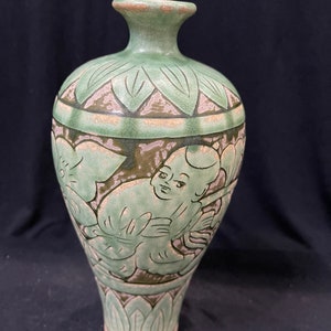 Chinese porcelain turquoise glazed vase carved baby and playing with flowers.
