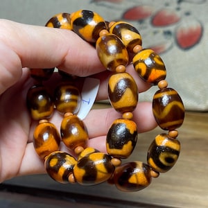 A Bracelet dzi bead tigers tooth pattern mix with 3 eyes orange black color