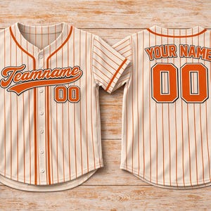 Peut inclure: Maillot de baseball crème avec des rayures et des détails orange. Il affiche "Teamname" et le numéro "00" à l'avant, et "YOUR NAME" et "00" au dos. Comprend des balles de baseball et un gant.