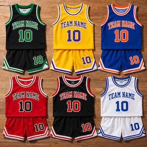 Op de afbeelding: Zes basketbaluniformsets in verschillende kleuren: zwart, geel, blauw, rood, zwart en wit. Elke set bevat een mouwloos shirt en een korte broek, beide met "TEAM NAME" en het nummer "10". De shorts tonen ook het nummer "10".